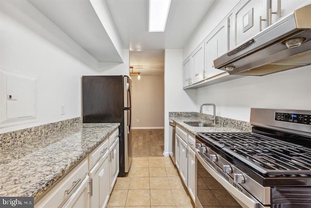 kitchen featuring light stone countertops, white cabinets, stainless steel appliances, sink, and light tile patterned floors