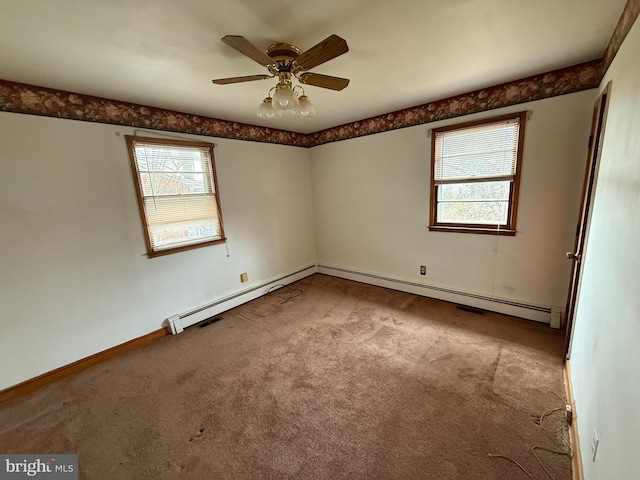 carpeted spare room with ceiling fan and a baseboard heating unit