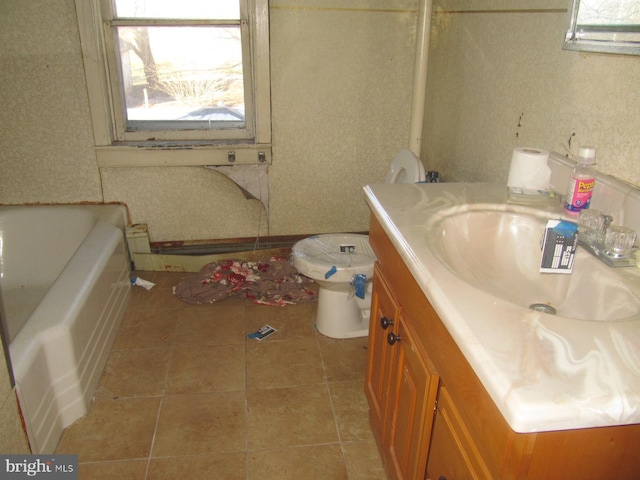 bathroom featuring toilet, tile patterned floors, a bath, and vanity