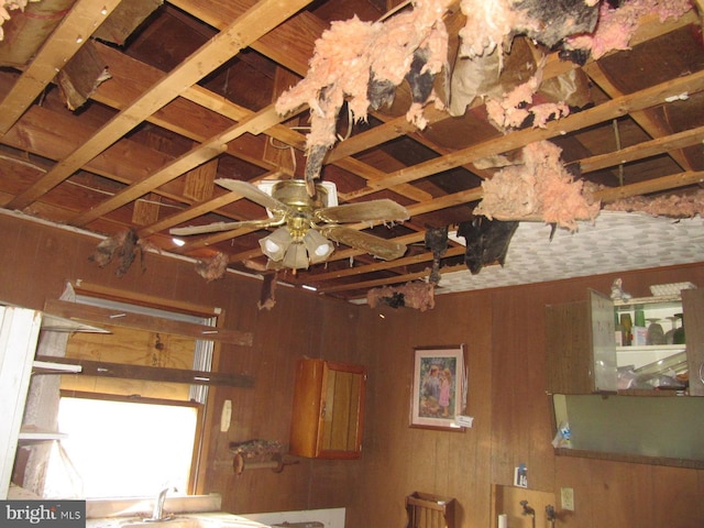 room details featuring ceiling fan and wooden walls