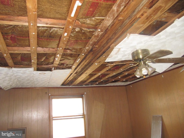 room details featuring ceiling fan and wooden walls