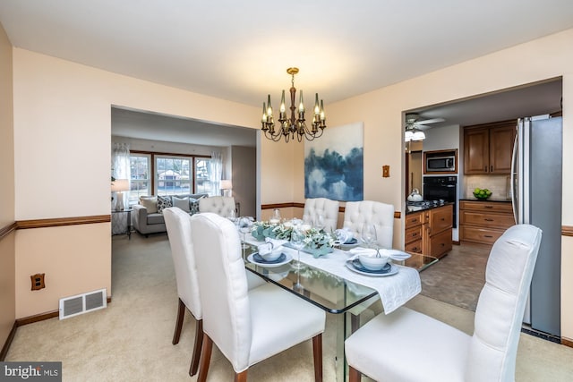 dining room featuring light carpet and a notable chandelier