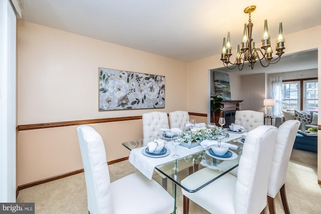 dining room featuring light carpet and a notable chandelier