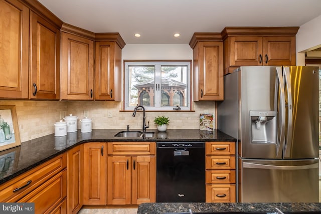 kitchen featuring sink, stainless steel fridge, dishwasher, dark stone countertops, and backsplash