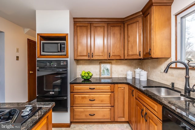 kitchen with sink, decorative backsplash, dark stone counters, and black appliances