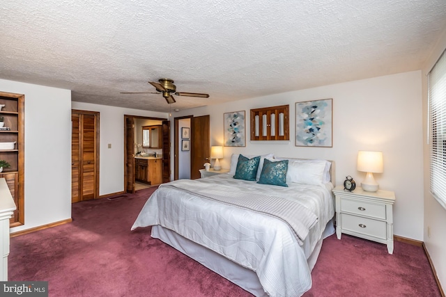 bedroom featuring ceiling fan, ensuite bath, a textured ceiling, and carpet flooring