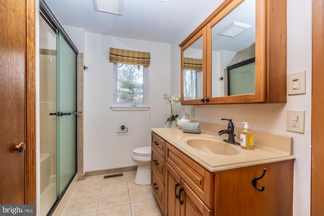 bathroom featuring walk in shower, vanity, toilet, and tile patterned flooring