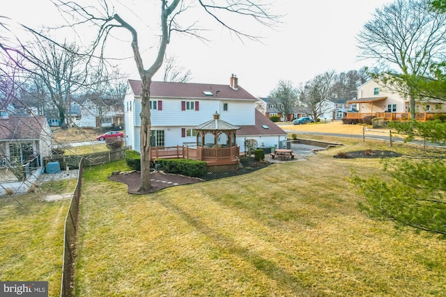 back of property with a yard, a gazebo, and a deck