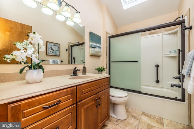 full bathroom featuring lofted ceiling with skylight, combined bath / shower with glass door, vanity, and toilet