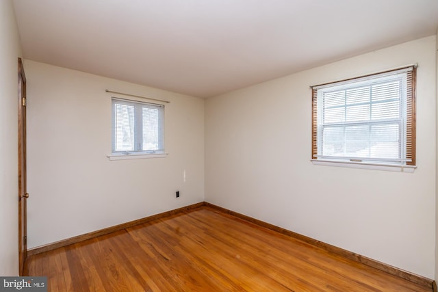 empty room with a wealth of natural light and light wood-type flooring