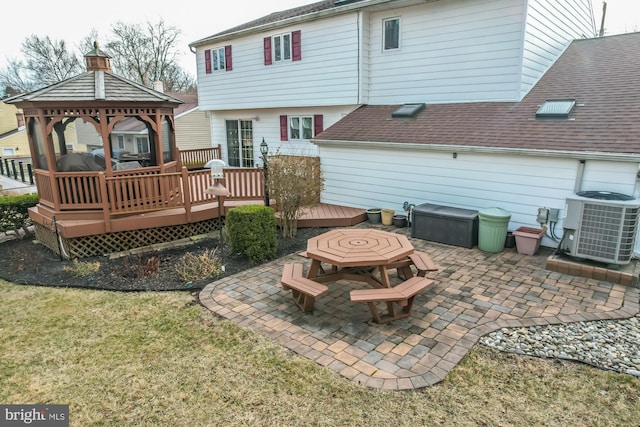 back of property featuring a patio area, a gazebo, a yard, cooling unit, and a deck