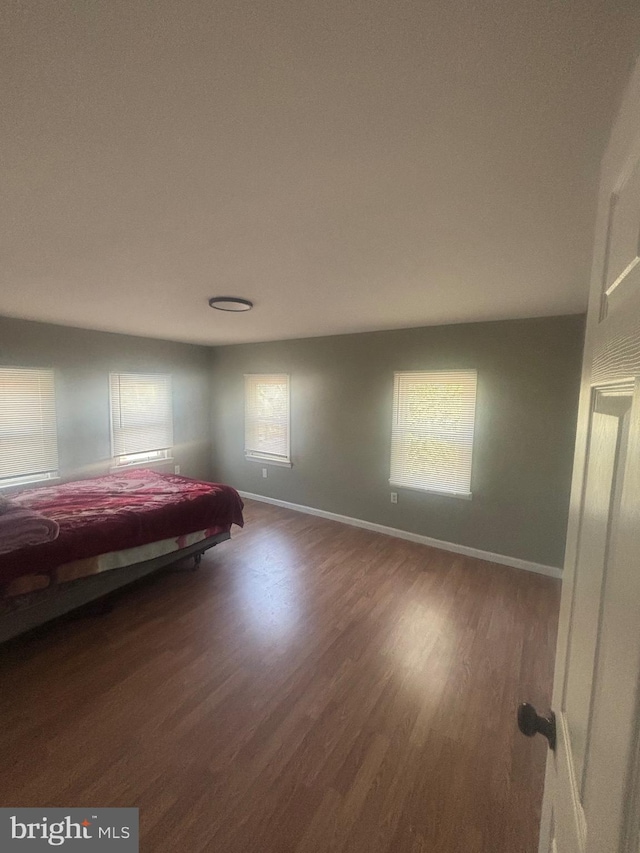 unfurnished bedroom with dark wood-type flooring