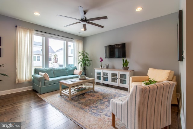 living room featuring dark wood-type flooring and ceiling fan