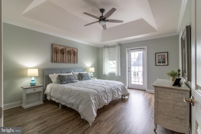 bedroom with access to exterior, ceiling fan, a tray ceiling, crown molding, and dark wood-type flooring