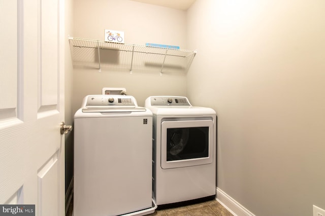 laundry area featuring light tile patterned floors and washer and clothes dryer