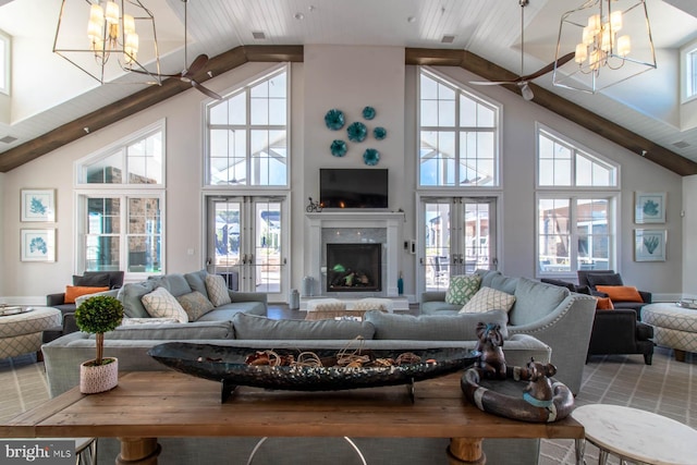 living room featuring high vaulted ceiling, french doors, and a chandelier