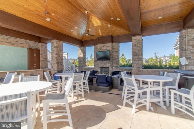 view of patio / terrace with ceiling fan and an outdoor stone fireplace