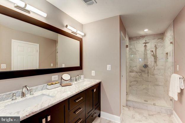 bathroom with a shower with shower door and vanity