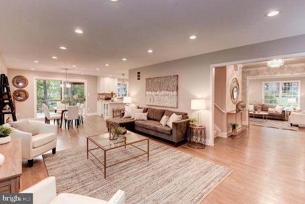 living room featuring light wood-type flooring and a chandelier