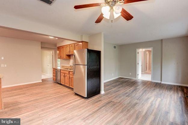 kitchen featuring light hardwood / wood-style floors, ceiling fan, appliances with stainless steel finishes, and sink