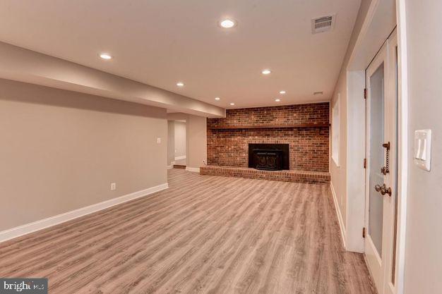 unfurnished living room with light hardwood / wood-style flooring and a wood stove