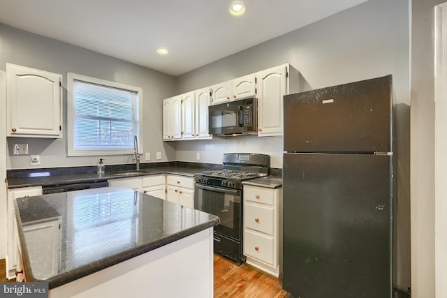 kitchen featuring black appliances, white cabinets, sink, and a kitchen island