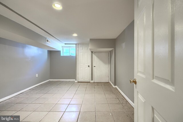 basement featuring light tile patterned flooring