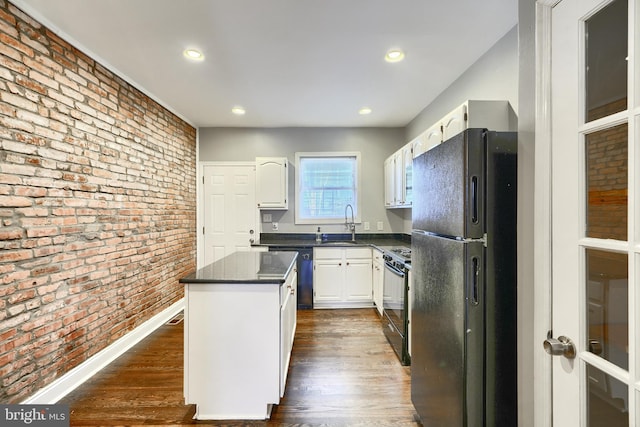 kitchen featuring a kitchen island, black appliances, dark wood-type flooring, white cabinets, and brick wall