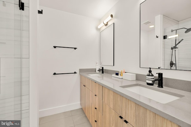 bathroom with an enclosed shower, vanity, and tile patterned flooring