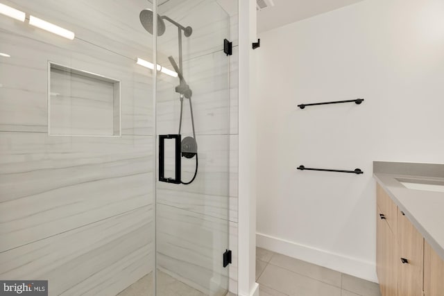 bathroom with tile patterned floors, walk in shower, and vanity