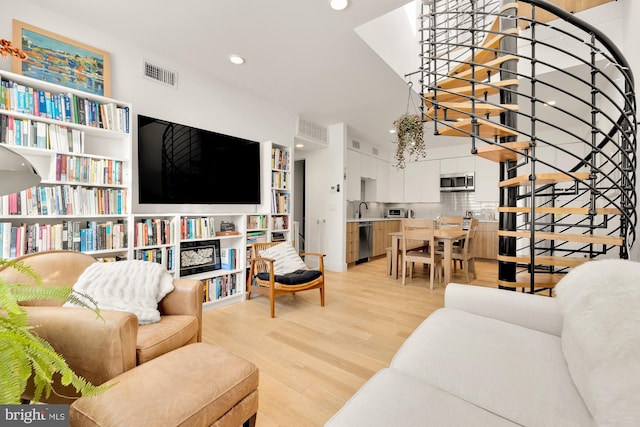 living room with light hardwood / wood-style floors and sink