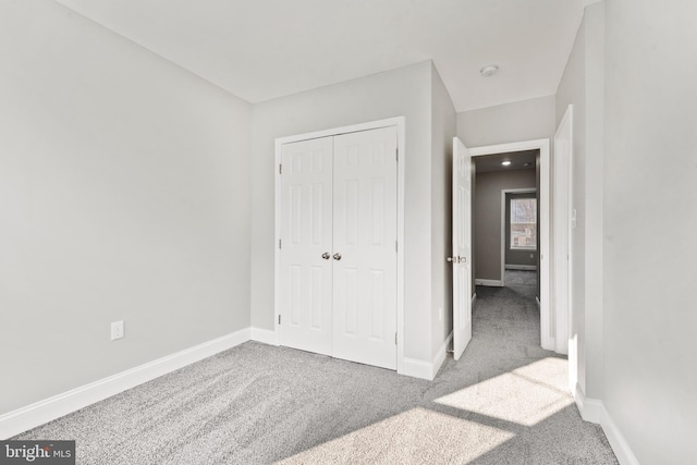 unfurnished bedroom featuring a closet and light carpet