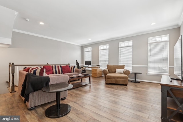 living room featuring light wood-type flooring, a healthy amount of sunlight, and crown molding