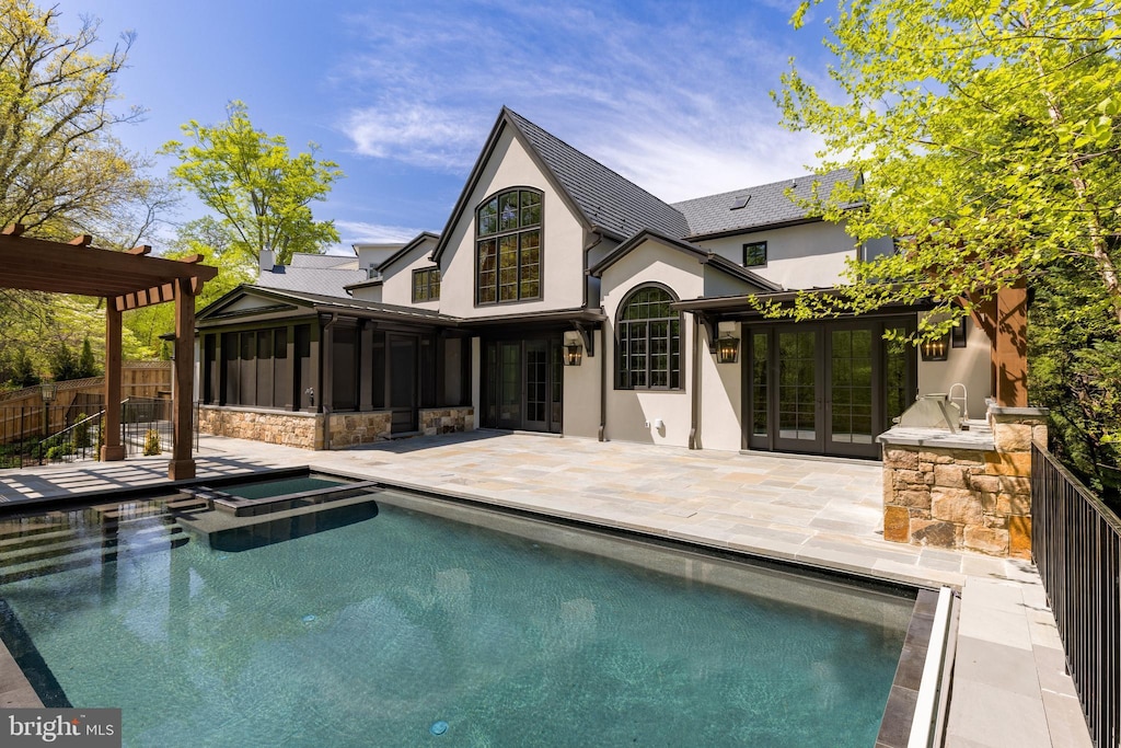 back of property featuring area for grilling, a swimming pool with hot tub, a pergola, a sunroom, and a patio area