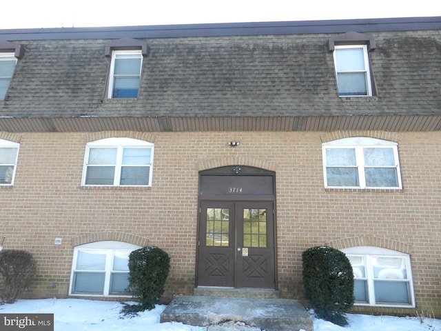 snow covered property entrance with french doors