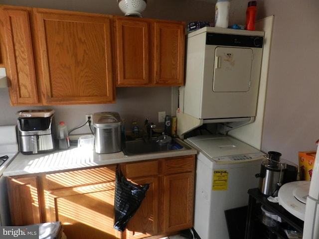 kitchen with stacked washer and clothes dryer and sink