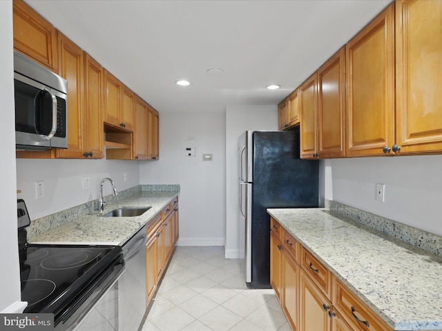 kitchen featuring light stone counters, stainless steel appliances, sink, and light tile patterned floors