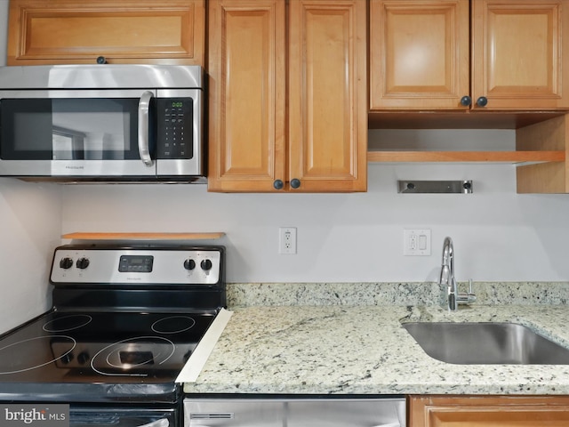 kitchen with light stone counters, sink, and stainless steel appliances