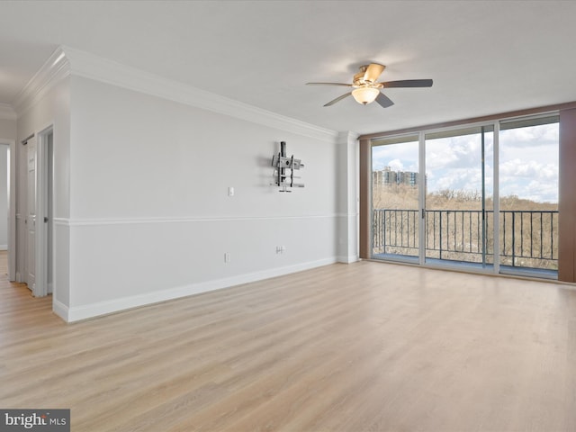 unfurnished room with crown molding, ceiling fan, expansive windows, and light hardwood / wood-style flooring