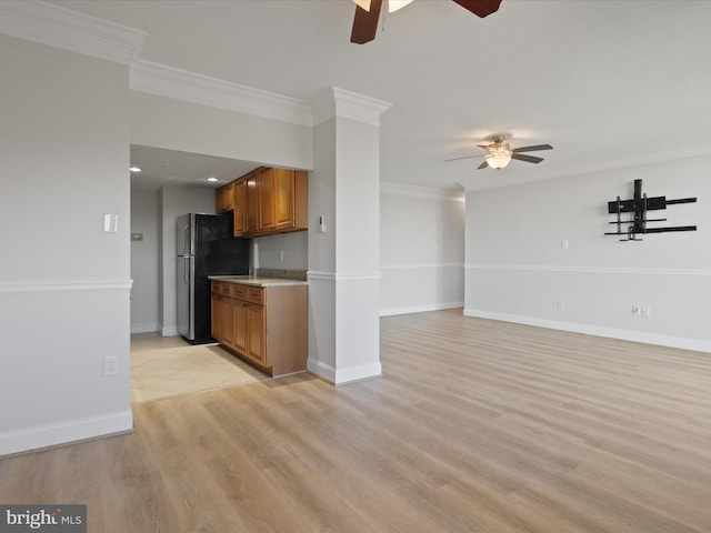 kitchen with crown molding, light wood-type flooring, ceiling fan, and stainless steel refrigerator