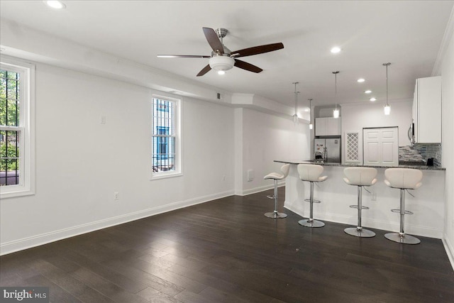 1631 U St SE, Washington, DC 20020 - kitchen featuring stainless steel appliances, a breakfast bar, dark wood-type flooring, recessed lighting, and decorative backsplash