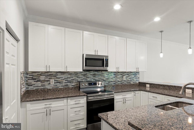 1631 U St SE, Washington, DC 20020 - kitchen with appliances with stainless steel finishes, white cabinets, tasteful backsplash, hanging light fixtures, and dark stone countertops
