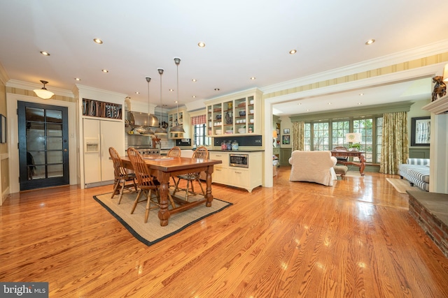 dining room featuring ornamental molding and light hardwood / wood-style flooring