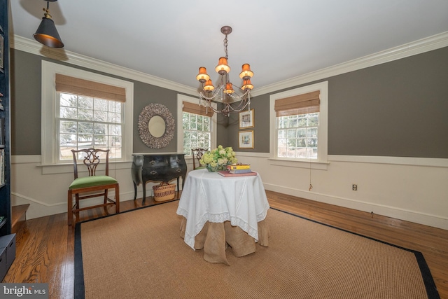 dining area featuring hardwood / wood-style floors, crown molding, and a chandelier