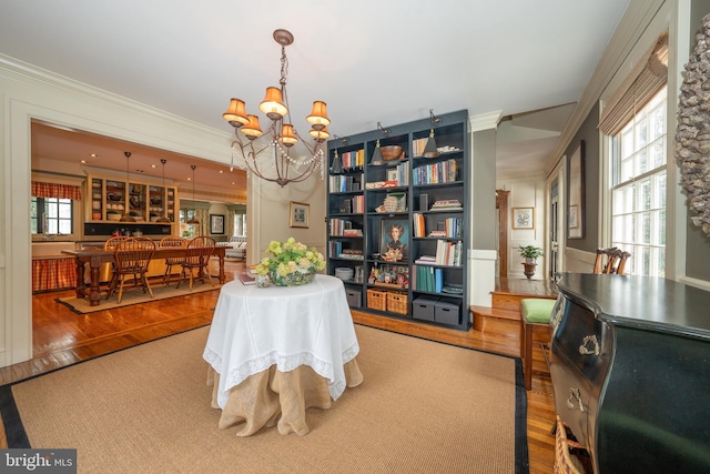 dining room featuring crown molding, hardwood / wood-style floors, and a notable chandelier