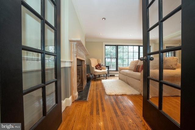 corridor featuring french doors, ornamental molding, and hardwood / wood-style floors