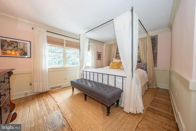 bedroom with wood-type flooring and crown molding