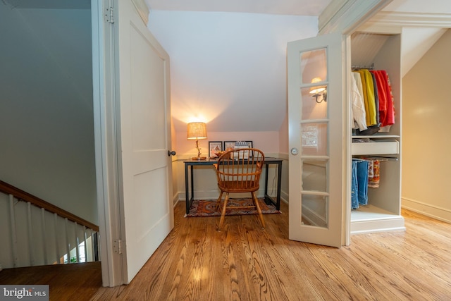 corridor with vaulted ceiling and light hardwood / wood-style floors