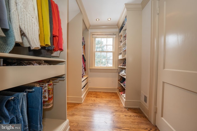 walk in closet with light hardwood / wood-style flooring