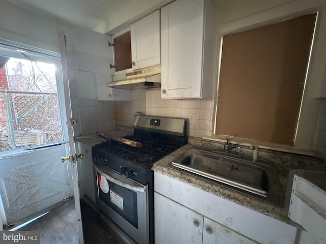 kitchen with stainless steel range with gas cooktop, backsplash, white cabinets, and sink